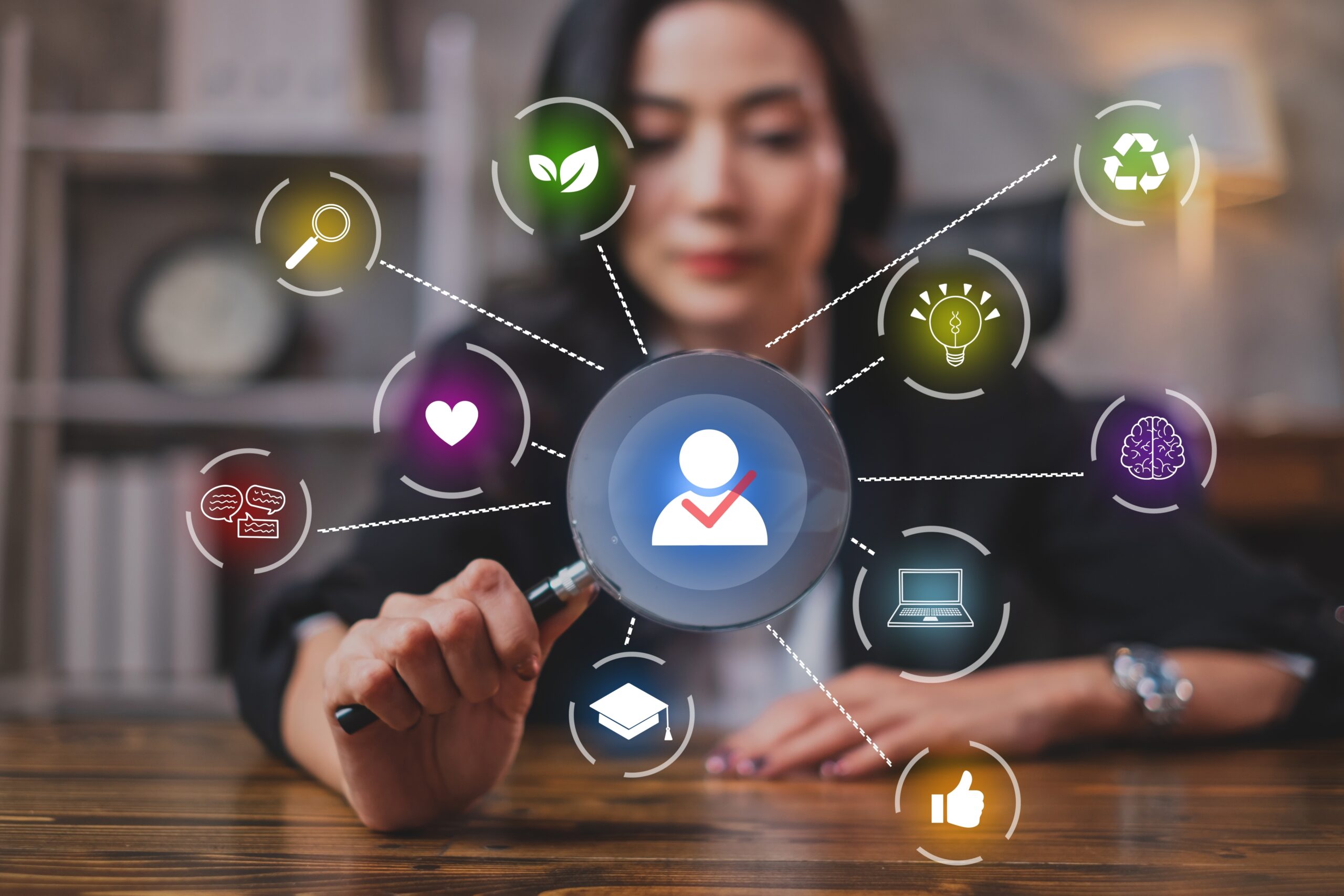 A businesswoman using a magnifying glass to highlight a candidate icon with a checkmark, surrounded by career-related icons, symbolizing job suitability and selection for freshers.