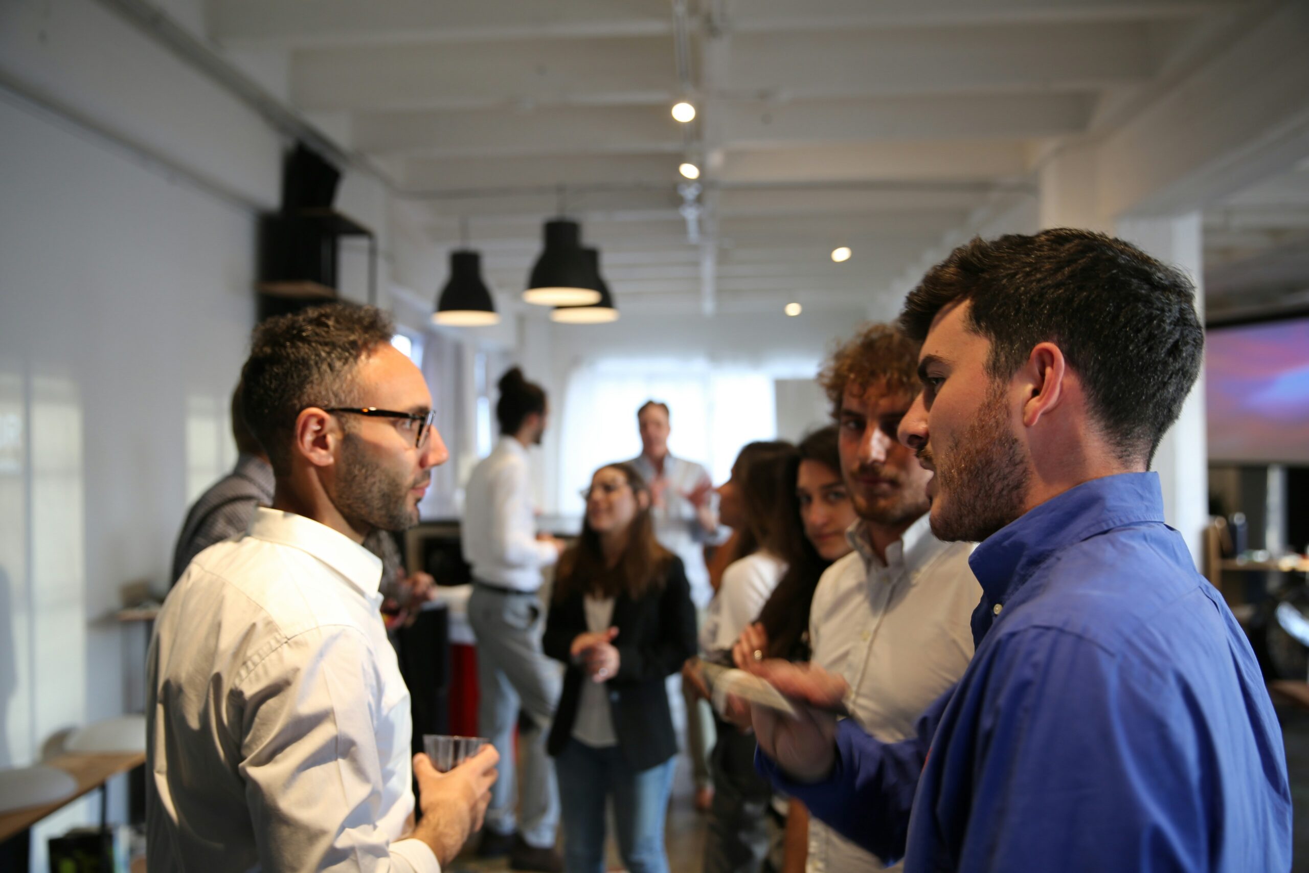 People networking and having conversations during a professional office event.