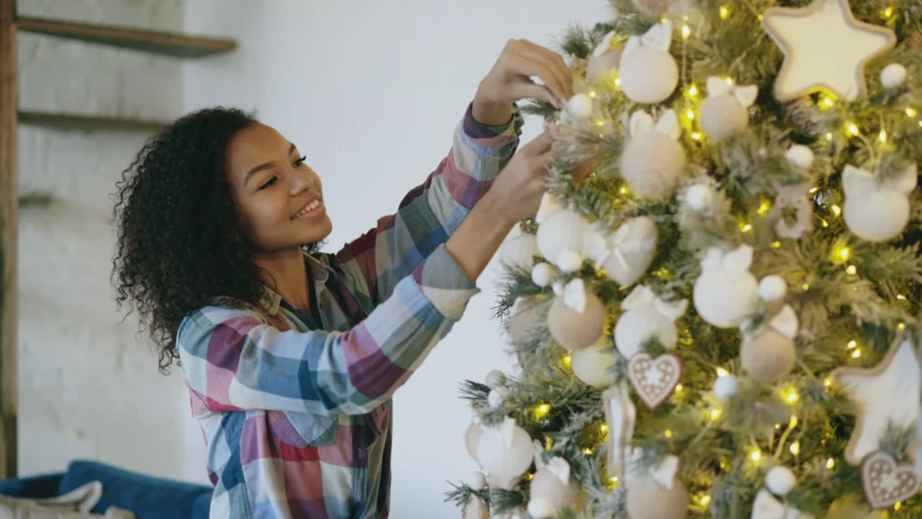 What Jobs Hire At 14 And 15 – young person decorating a Christmas tree, representing holiday decorating and seasonal job opportunities for teenagers.