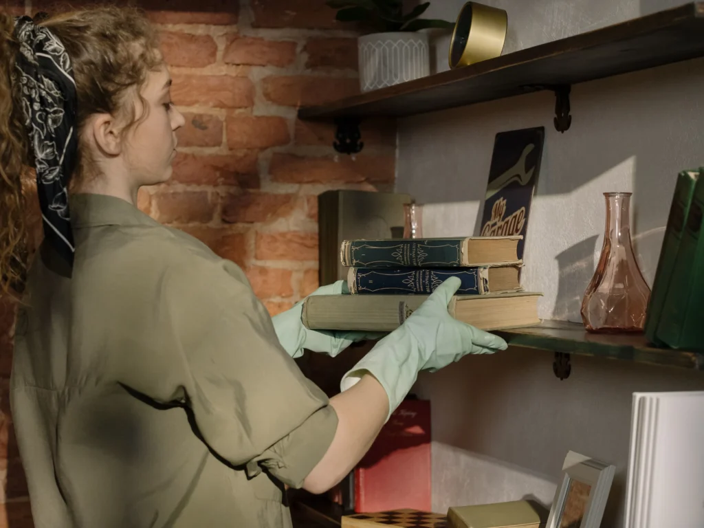 What Jobs Hire At 14 And 15 – teen organizing and shelving books, representing library assistant and book shelving job opportunities for teenagers.
