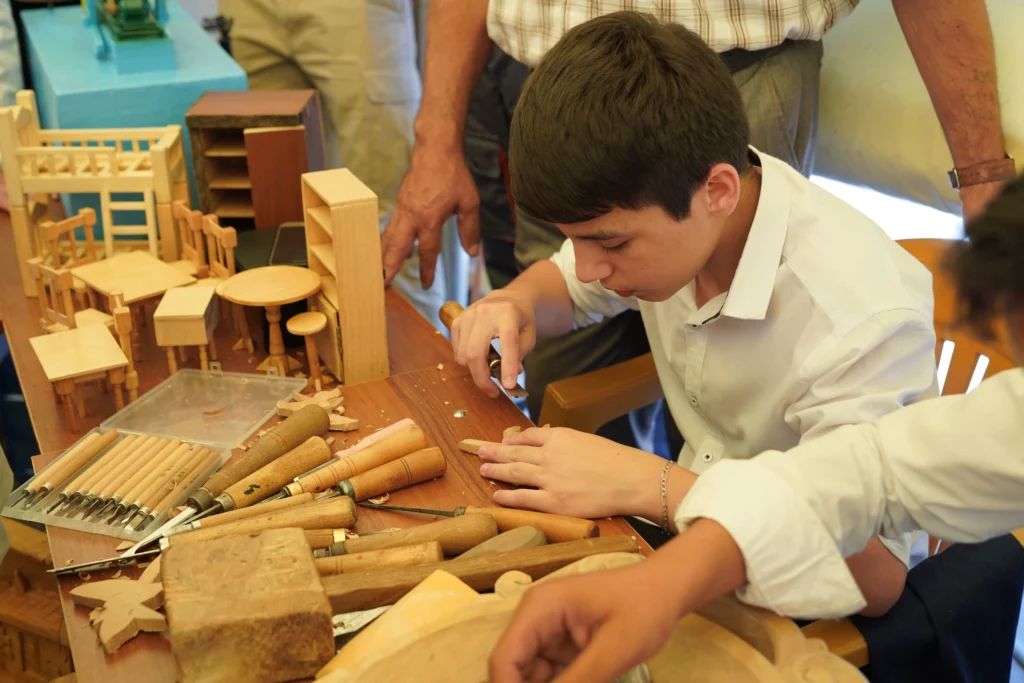 What Jobs Hire At 14 And 15 – teen working on a woodworking project with hand tools, representing woodworking, craft, and workshop job opportunities for teenagers.